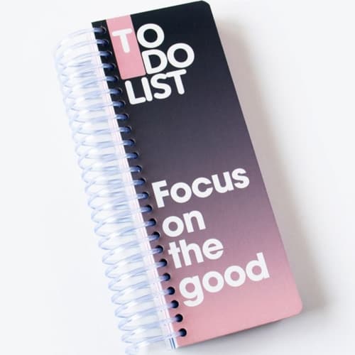 دفترچه فهرست کارها با جلد مشکی و صورتی، صحافی سیمی و عبارت انگلیسی «TO DO LIST؛ Focus on the good